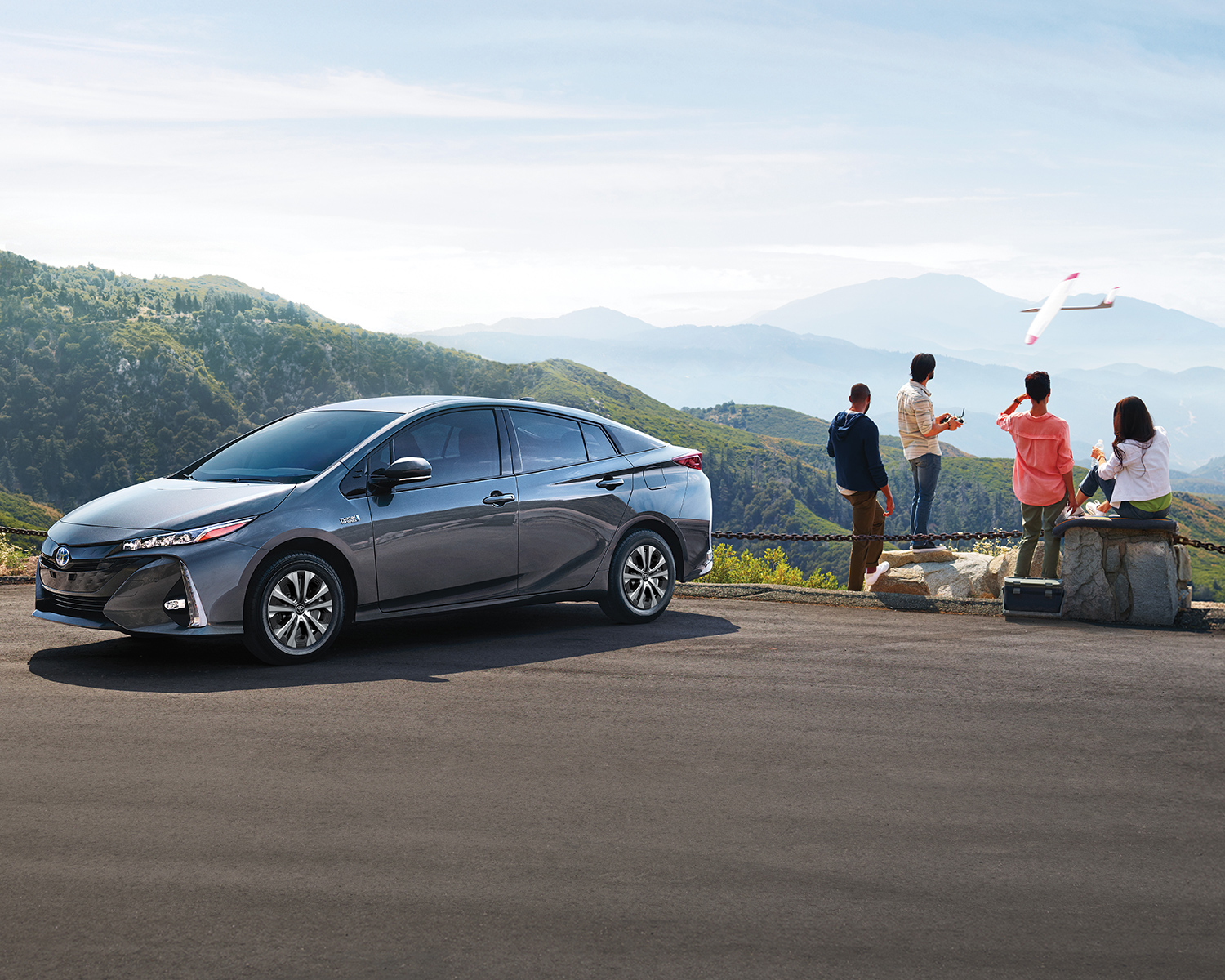 Toyota Prius devant une famille admirant des montagnes